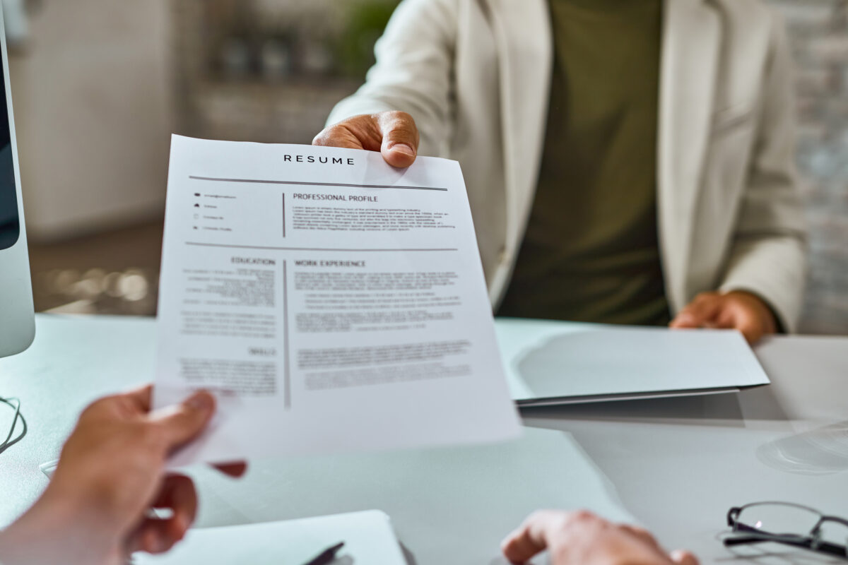 Close-up of job applicant giving his resume during job interview in an office.concept image for how to applay for work abroad as a South African